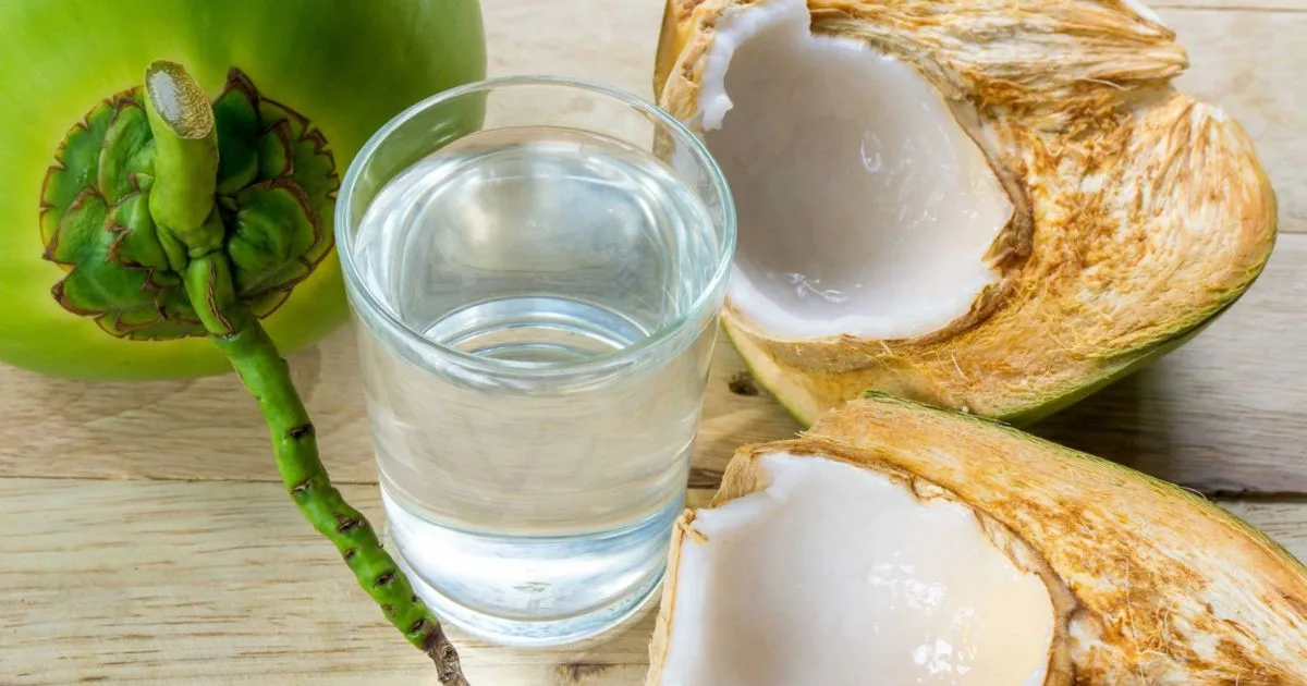 Fresh pure 100% coconut water in glass with open coconut